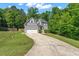View of the home showing the driveway and front yard with mature trees in the background at 9300 Glendora Ct, Garner, NC 27529