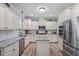 Bright kitchen boasts granite counters, stainless appliances, white cabinets, and a center island at 9300 Glendora Ct, Garner, NC 27529