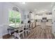 Eat-in kitchen showcasing white cabinets, granite countertops, stainless appliances, and hardwood flooring at 9300 Glendora Ct, Garner, NC 27529