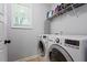 Functional laundry room with modern washer and dryer, plus ample shelving for storage at 9300 Glendora Ct, Garner, NC 27529
