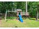 Backyard play area with a slide and swing set, surrounded by mature trees and greenery at 9300 Glendora Ct, Garner, NC 27529
