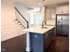 Stylish kitchen island boasts quartz countertops, a stainless sink, and bar seating at 931 Haybeck Ln, Apex, NC 27523