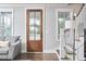 Inviting entryway with wood door, hardwood floors, and natural light from surrounding windows at 941 W Club Blvd, Durham, NC 27701