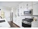 Stylish kitchen featuring stainless steel appliances, sleek white cabinetry, and modern finishes at 941 W Club Blvd, Durham, NC 27701