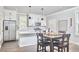 Modern kitchen with white cabinetry, stainless appliances, and a dining area at 941 W Club Blvd, Durham, NC 27701