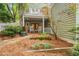 View of the back of the house with a covered brick patio and two rocking chairs at 102 Newell St, Chapel Hill, NC 27516