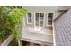View from above showing patio set on a second-story balcony with white railings and lush green trees at 102 Newell St, Chapel Hill, NC 27516