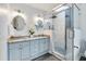 Bathroom features modern vanities, a skylight, and a glass enclosed shower with white and gray tile at 102 Newell St, Chapel Hill, NC 27516