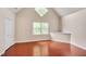 Bedroom features red hardwood floors, vaulted ceilings, an oversized window, and white paint at 102 Newell St, Chapel Hill, NC 27516
