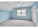 Light blue bedroom has gray carpet, a ceiling fan, closet, and a large window overlooking the yard at 102 Newell St, Chapel Hill, NC 27516