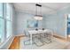 Dining room with a modern chandelier, light blue walls, and hardwood floors at 102 Newell St, Chapel Hill, NC 27516