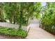Home's exterior showing white garage door, white picket fence, lush green trees, and concrete driveway at 102 Newell St, Chapel Hill, NC 27516