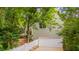 Home's exterior showing white garage door, white picket fence, lush green trees, and concrete driveway at 102 Newell St, Chapel Hill, NC 27516