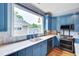 Kitchen with blue cabinets, stainless steel appliances, white countertops, and hardwood floors at 102 Newell St, Chapel Hill, NC 27516