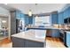Kitchen with blue cabinets, stainless steel appliances, a large island, and hardwood floors at 102 Newell St, Chapel Hill, NC 27516