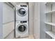 Bright laundry room with stacked washer/dryer and shelving for efficient organization at 102 Newell St, Chapel Hill, NC 27516