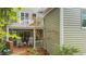 Back of home featuring brick porch with rocking chairs, and second level balcony with white railings and patio set at 102 Newell St, Chapel Hill, NC 27516
