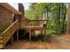 A wooden deck with access stairs, showing an exterior view of a brick house and yard at 103 Tiara Ct, Garner, NC 27529