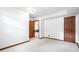 An unfinished basement area features white walls, carpeting, and a wood door at 103 Tiara Ct, Garner, NC 27529