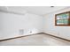 An unfinished basement area features white walls, carpeting, and natural light from a wood framed window at 103 Tiara Ct, Garner, NC 27529