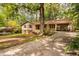 View of home with tan siding, brown shutters, brick accents, and a side carport at 103 Tiara Ct, Garner, NC 27529