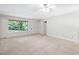 Bright living room with neutral carpet, large window, and ceiling fan at 103 Tiara Ct, Garner, NC 27529