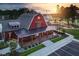 Exterior of a community clubhouse featuring a covered porch, red barn styling, and green surroundings at 104 Restful Pt, Fuquay Varina, NC 27526