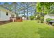 Spacious backyard with a deck, green lawn, and mature trees at 110 Phyllis Dr, Benson, NC 27504