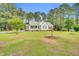 Beautifully landscaped front yard with a charming single-story home nestled amongst mature trees at 110 Phyllis Dr, Benson, NC 27504