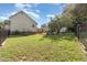 Sprawling backyard featuring green grass, chain link fencing, and outbuildings at 1211 Azalea Dr, Zebulon, NC 27597