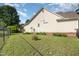 Sprawling backyard featuring a home, green grass, a brick foundation, and a chain link fence at 1211 Azalea Dr, Zebulon, NC 27597