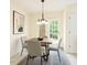Bright dining area features an elegant light fixture, seating for four, and sliding glass door to the outdoor at 1211 Azalea Dr, Zebulon, NC 27597