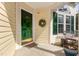 Inviting front porch with a dark green front door, wreath, and seating area, ideal for relaxing at 1211 Azalea Dr, Zebulon, NC 27597