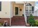 Inviting front porch with brick stairs, white railing, and stylish decor at 1211 Azalea Dr, Zebulon, NC 27597