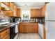 Functional kitchen features wooden cabinets, tile backsplash, and essential appliances at 1211 Azalea Dr, Zebulon, NC 27597