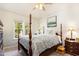 Sunlit main bedroom boasts a four-poster bed, complemented by a ceiling fan for added comfort at 1211 Azalea Dr, Zebulon, NC 27597
