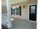 Inviting front porch with black door, decorative window, and stylish exterior wall lighting at 1249 Turkey Trot Rd, Wendell, NC 27591
