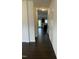 Hallway with hardwood floors leading to the kitchen, living area and white doors at 1249 Turkey Trot Rd, Wendell, NC 27591