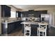 Modern kitchen featuring black cabinetry, granite countertops, stainless steel appliances, and a breakfast bar at 1249 Turkey Trot Rd, Wendell, NC 27591