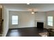 Bright living room with dark hardwood floors, fireplace, ceiling fan, and staircase at 1249 Turkey Trot Rd, Wendell, NC 27591