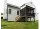 Backyard view of a home with a screened porch and wooden stairs to the back door at 1333 Beaufort Dr, Graham, NC 27253