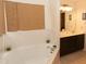 Bright bathroom featuring a soaking tub with tile surround and a vanity with double sinks at 1333 Beaufort Dr, Graham, NC 27253