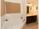 Bright bathroom featuring a soaking tub with tile surround and a vanity with double sinks at 1333 Beaufort Dr, Graham, NC 27253