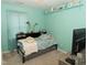 Cozy bedroom with bright teal walls, plush carpet, and natural light from the window at 1333 Beaufort Dr, Graham, NC 27253