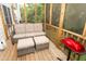 Comfortable seating area on a screened in porch with a red grill at 1333 Beaufort Dr, Graham, NC 27253