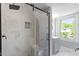 This bathroom offers a large glass shower with bench and gray vanity at 134 Nelson St, Durham, NC 27707