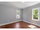Serene bedroom with hardwood floors, neutral walls, and natural light from two windows at 134 Nelson St, Durham, NC 27707