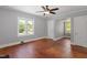 Bright bedroom featuring hardwood floors, a ceiling fan, and natural light from two windows at 134 Nelson St, Durham, NC 27707