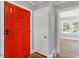 Bright entryway featuring a bold red front door, hardwood floors, and freshly painted walls at 134 Nelson St, Durham, NC 27707
