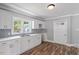 Bright kitchen featuring white cabinets, stainless steel sink, and modern backsplash at 134 Nelson St, Durham, NC 27707